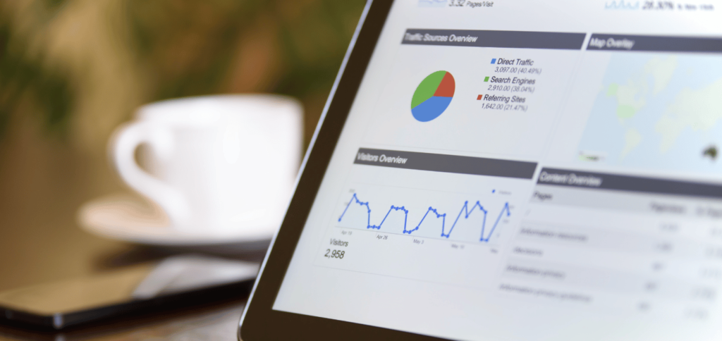 Partial view of analytics report on tablet screen with white coffee mug in background